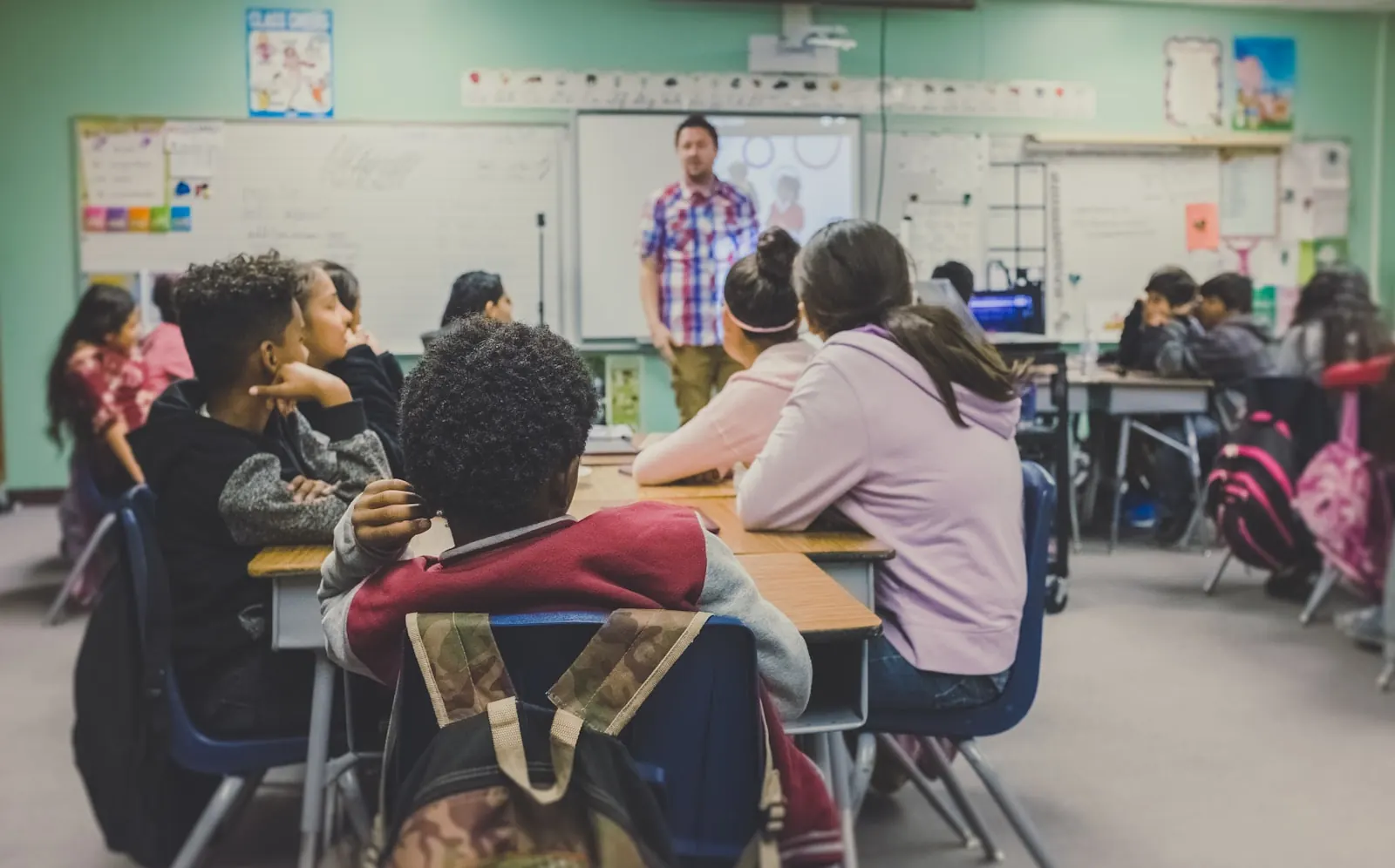Teacher using a laptop in a modern school